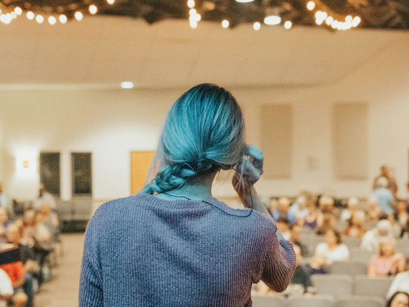 femme devant une assemblée de personnes